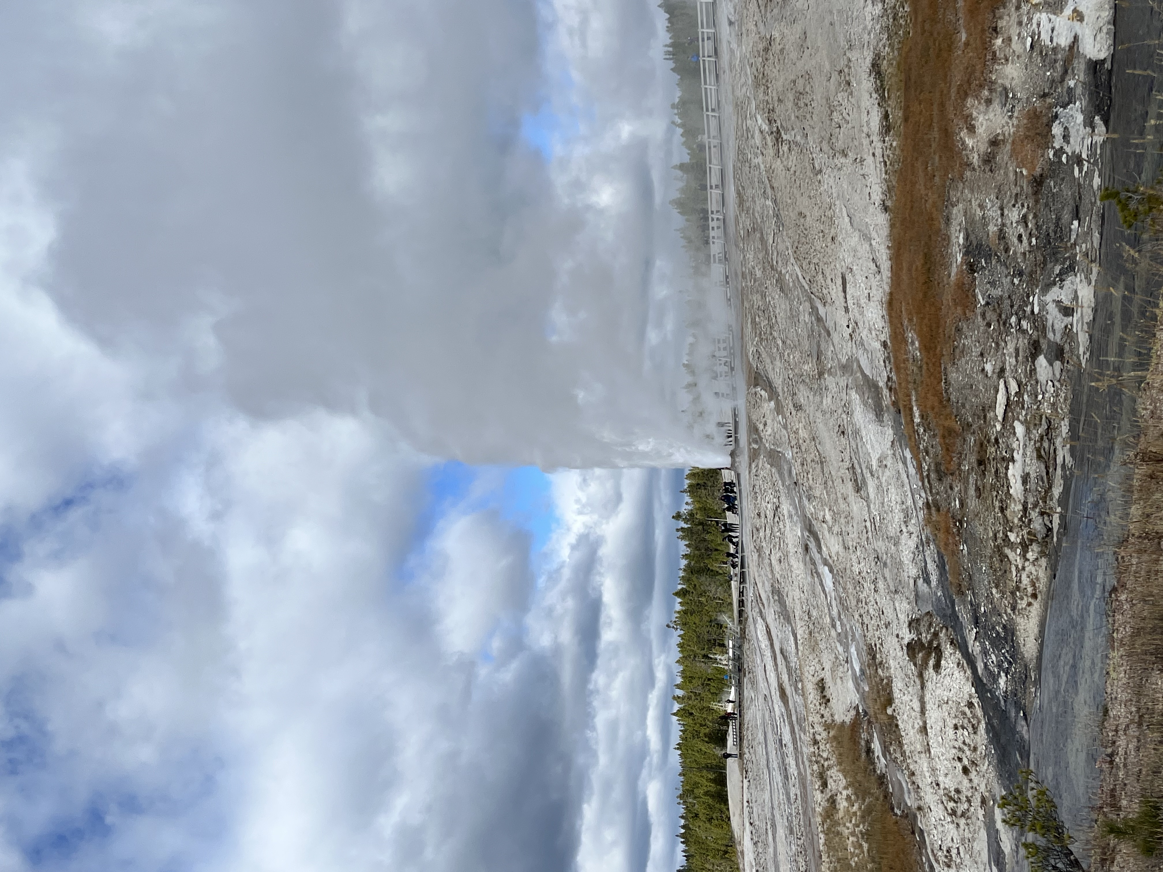 A geyser shooting water and steam high into a blue sky