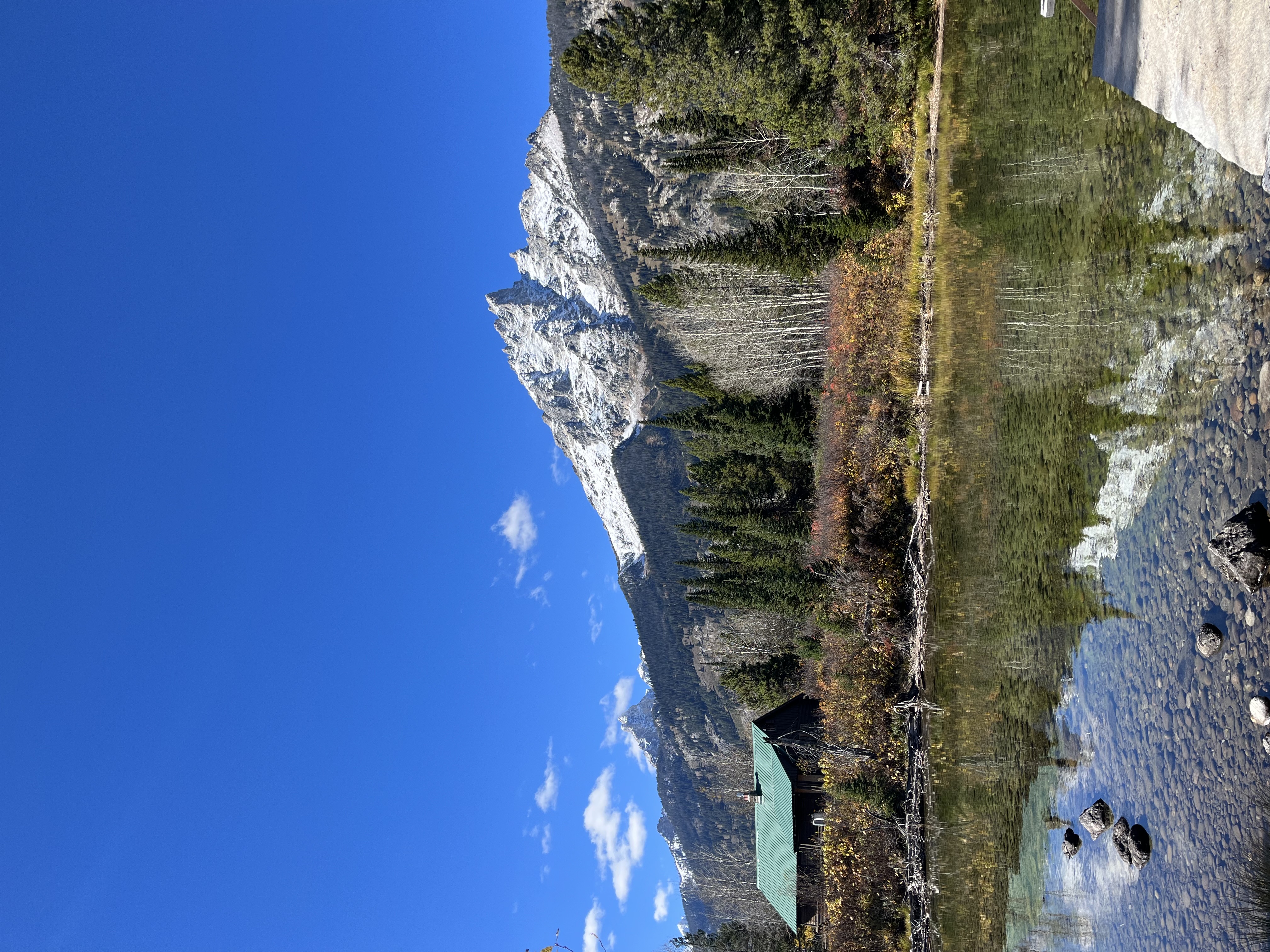 Snow-capped mountains reflecting into calm water